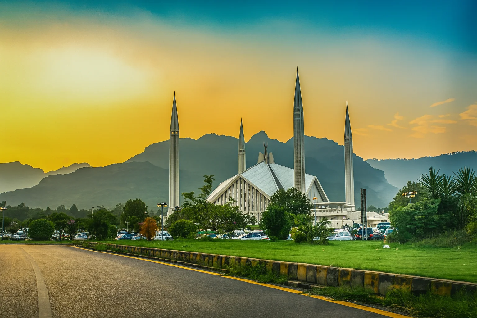 Faisal Mosque view in Islamabad near NEOM Rent a Car offices, surrounded by lush greenery and scenic Margalla Hills at sunset.